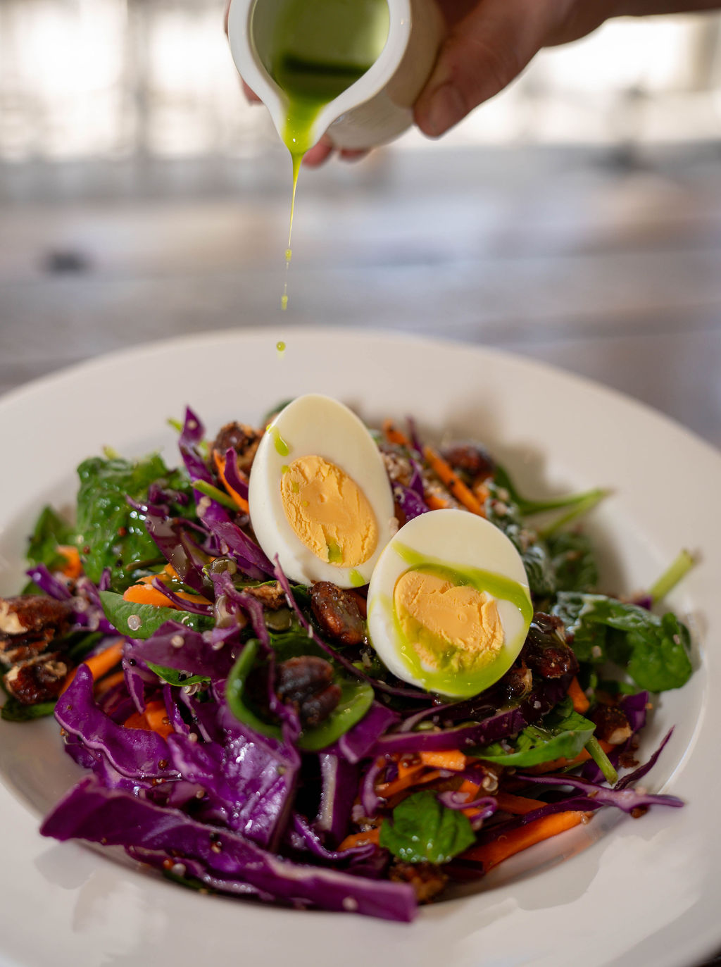 Colourful salad with boiled egg and green dressing